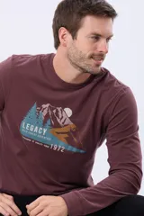 Remera de manga larga color bordó, con cuello redondo y estampado frontal de un paisaje montañoso con pinos y la palabra "LEGACY".