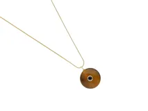 Collar de cadena fina con baño de oro y dije circular de piedra natural ojo de tigre con una circonia azul engastada en el centro.