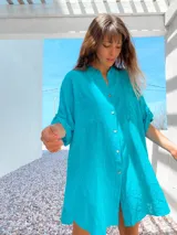 Camisola de lino rústico en color turquesa, con cuello mao, cierre frontal de botones y bolsillos delanteros. Presenta mangas tres cuartos con detalle de ajuste.