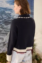 Cardigan de punto azul marino con cuello tejido a mano en crochet color crudo, cierre frontal con botones y detalles en tono borravino y crudo en los bordes y puños semióxford.