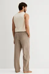 Pantalón de corte relajado confeccionado en franela de algodón suave, con diseño a cuadros. Presenta cintura elástica con cordón ajustable, cierre decorativo y bolsillos laterales al bies.