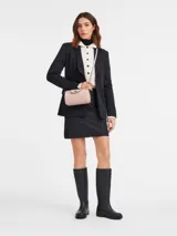 Bandolera Longchamp modelo Le Pliage Xtra XS, color rosa pálido, con correa ajustable y cierre de solapa con botón a presión.