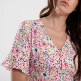 Vestido corto con estampado floral en tonos rojos y celestes, con escote en V y mangas cortas acampanadas.