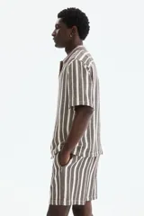 Short de corte regular fit en tejido texturizado con mezcla de algodón, con diseño de rayas verticales en tonos marrón y crudo. Cuenta con cintura elástica ajustable con cordón y bolsillos laterales.