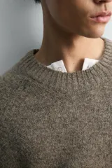 Jersey de punto con textura, corte relajado, cuello redondo y manga larga con terminaciones en rib.