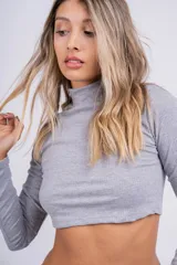 Polera crop top de manga larga en tejido acanalado, con cuello alto y ajuste al cuerpo.