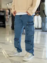 Pantalón de jean estilo cargo, color azul, de corte ancho y holgado, con múltiples bolsillos laterales en muslos y pantorrillas.