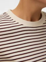 Remera de manga corta con hombros caídos y cuello redondo, de corte regular. Confeccionada en tejido de punto circular con acabado interlock, con rayas horizontales en color crema y marrón oscuro.