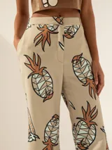 Pantalón semi oxford color beige con estampado de ananás, confeccionado en tejido elastizado.