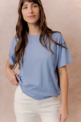 Remera negra de corte oversize con cuello redondo, mangas cortas amplias, hombros caídos y recortes delanteros.