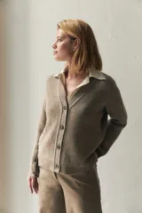 Cárdigan color crema de tejido de punto industrial con escote en V, combinación de puntos y botones decorativos en las mangas.