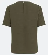 Blusa blanca de poliéster con cuello redondo, mangas cortas, cierre trasero en forma de gota, pequeñas aberturas laterales y acabados en pespuntes en las mangas y el cuello.