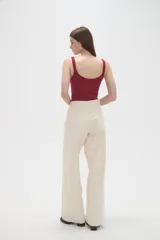 Pantalon de jean de corte ancho y tiro medio, en color natural, con cierre frontal y bolsillos laterales.