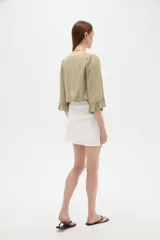 Minifalda blanca de viscosa con diseño cruzado y frunces en la cintura.