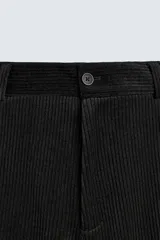 Pantalón de corte wide fit confeccionado en pana de algodón color marrón oscuro. Presenta bolsillos frontales, bolsillos traseros de vivo con botón y cierre frontal con cremallera y botón.