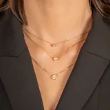 Conjunto de tres collares de cadena fina tipo veneciana en plata 925 con baño de oro, cada uno con un dije de punto de luz con circonia engastada en bisel.