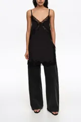 Pantalón de mezclilla negro de corte wide leg, con diseño holgado y tiro bajo.