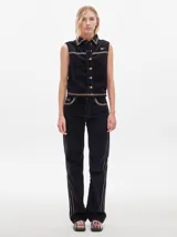 Pantalón de pana roja con corte holgado y tiro medio. Presenta una línea dorada a lo largo de la pierna.