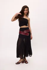 Falda larga negra de chiffon con transparencias, goudets que generan vuelo y costuras desflecadas.