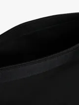 Mochila negra de poliéster con diseño de solapa enrollable y cierre de apertura rápida con hebilla. Presenta un parche con el logo de Tommy Jeans en la parte inferior frontal.