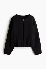 Campera negra de felpa con efecto neopreno, corte oversized y hombros caídos. Presenta cuello redondo, cierre frontal metálico, bolsillos delanteros insertados y elástico revestido en puños y bajo.