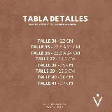 Bota corta tipo chelsea de cuero vacuno color negro, con elásticos laterales, taco cuadrado de madera y suela de caucho.