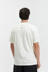 Remera de manga corta color marrón, con ajuste regular y escote redondo. Presenta un estampado frontal con texto en blanco formando un diseño circular.