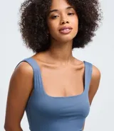 Vestido largo tipo midi de corte ajustado, confeccionado en poliamida con elastano. Presenta escote cuadrado, breteles anchos y una abertura lateral en el ruedo.