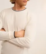 Sweater de manga larga color azul marino con textura acanalada vertical. Presenta un cuello redondo con un ribete blanco contrastante y un borde inferior con un detalle blanco asomando.