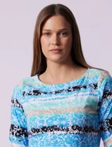 Remera de algodón con estampado floral y de rayas horizontales en tonos azules, negros y beige. Presenta escote redondo a la base y mangas tres cuartos.