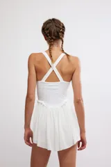 Vestido corto deportivo negro con efecto smock en el torso, tirantes finos blancos y falda de vuelo suave.