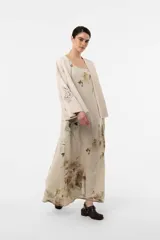 Vestido largo verde militar con estampado floral, silueta amplia y fluida, escote redondeado y breteles con detalle de botones.