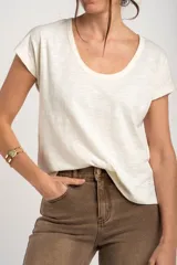 Remera de algodón flame color blanco marfil, con cuello redondo amplio y mangas cortas holgadas.