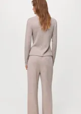 Jersey de punto color gris claro, con cuello alto y manga larga.
