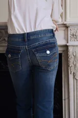Jean de tiro bajo con corte acampanado desde la rodilla. Confeccionado en denim con leve stretch, presenta bolsillos delanteros abiertos y bolsillos traseros con solapa y botón.