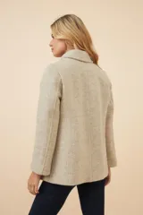 Chaquetón de lana fina color beige con cuello solapa, doble abotonadura frontal, bolsillos ojal y forro al tono.