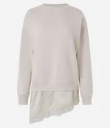 Buzo de algodón con felpa, corte oversized, cuello redondo y mangas largas. Presenta un detalle de encaje aplicado en el ruedo, aportando un contraste femenino y sofisticado.