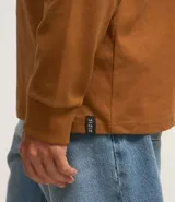 Remera de manga larga con cuello redondo, confeccionada en algodón. Presenta un corte comfort holgado y una pequeña etiqueta decorativa en el bajo.