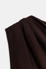 Top de tejido punto color marrón oscuro, con escote asimétrico tipo *one-shoulder* y drapeado frontal.