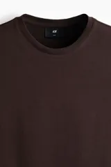 Remera de algodón liviano color marrón, de corte ajustado, cuello redondo ribeteado y mangas cortas.