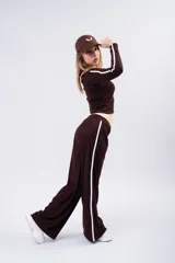 Pantalón tipo palazzo de corte amplio y fluido, color negro, con doble línea lateral blanca y cintura elástica.
