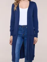 Cardigan largo de punto liviano y suave, de color blanco, con diseño abierto al frente, mangas largas con puños acanalados y bolsillos frontales aplicados.