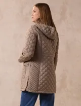 Campera capitoneada de corte largo con diseño acolchado en forma de rombos. Cuenta con cierre frontal completo, capucha desmontable, bolsillos delanteros con solapa y cierre, y forro interno a tono.