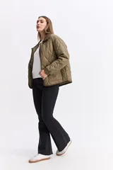 Campera matelaseada de diseño en rombos color verde oliva, con cuello y bordes en contraste color marrón. Presenta cierre frontal con botones a presión, mangas largas con puños elásticos y corte holgado.