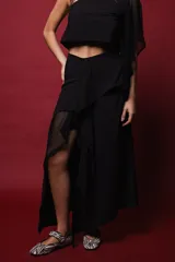 Falda midi negra con base de mini falda y capas superpuestas de crepé y microtul, con volados irregulares.