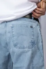 Bermuda de jean con lavado ácido, corte mom y estilo carpintero con bolsillos laterales utilitarios.