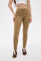 Pantalon skinny de tiro alto color beige, con bolsillos laterales y traseros simulados.