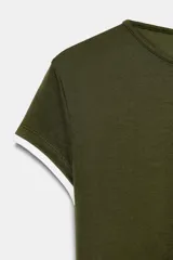 Camiseta de corte slim fit, color verde militar, con cuello redondo y manga corta. Presenta vivos de contraste blancos en el ruedo de las mangas y en el bajo.