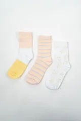 Pack de tres pares de medias de caña media. Un par a rayas horizontales en tonos pastel, un par blanco con estrellas de colores y un par con bloques de color amarillo, blanco y salmón.