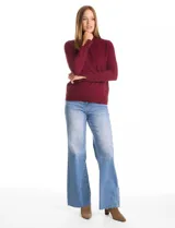 Polera de cuello alto confeccionada en tejido de punto fino, con mangas largas y detalle de tajo en los puños.